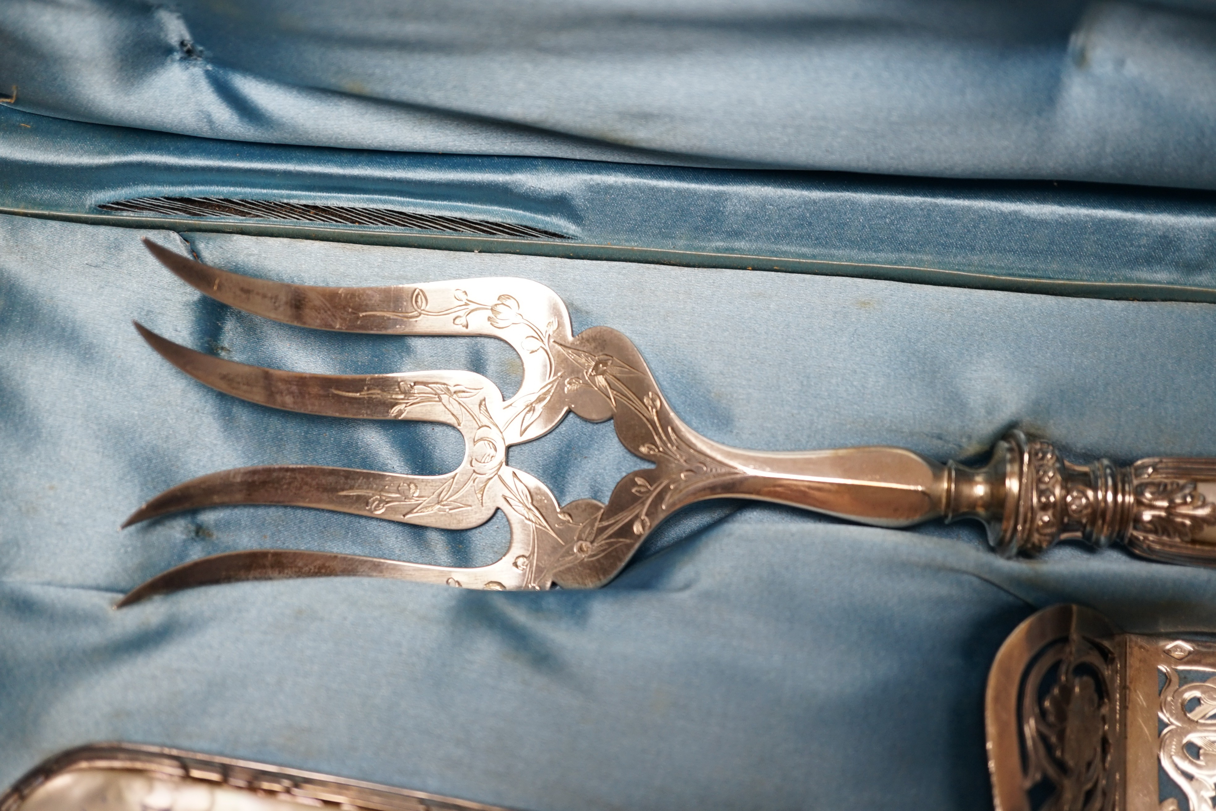 A cased ornate French white metal and mother of pearl mounted serving set, comprising a pair of fish servers and a cake server, maker JM.